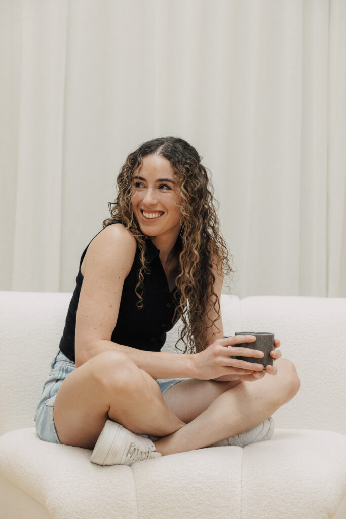 Female physio sitting on couch with coffee cup